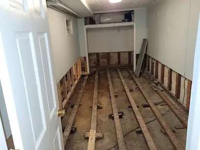 Air movers and a dehumidifier drying a flooded Brockton basement